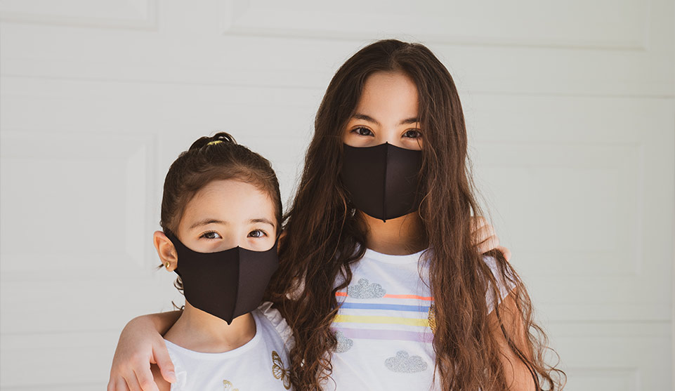 two girls wearing masks