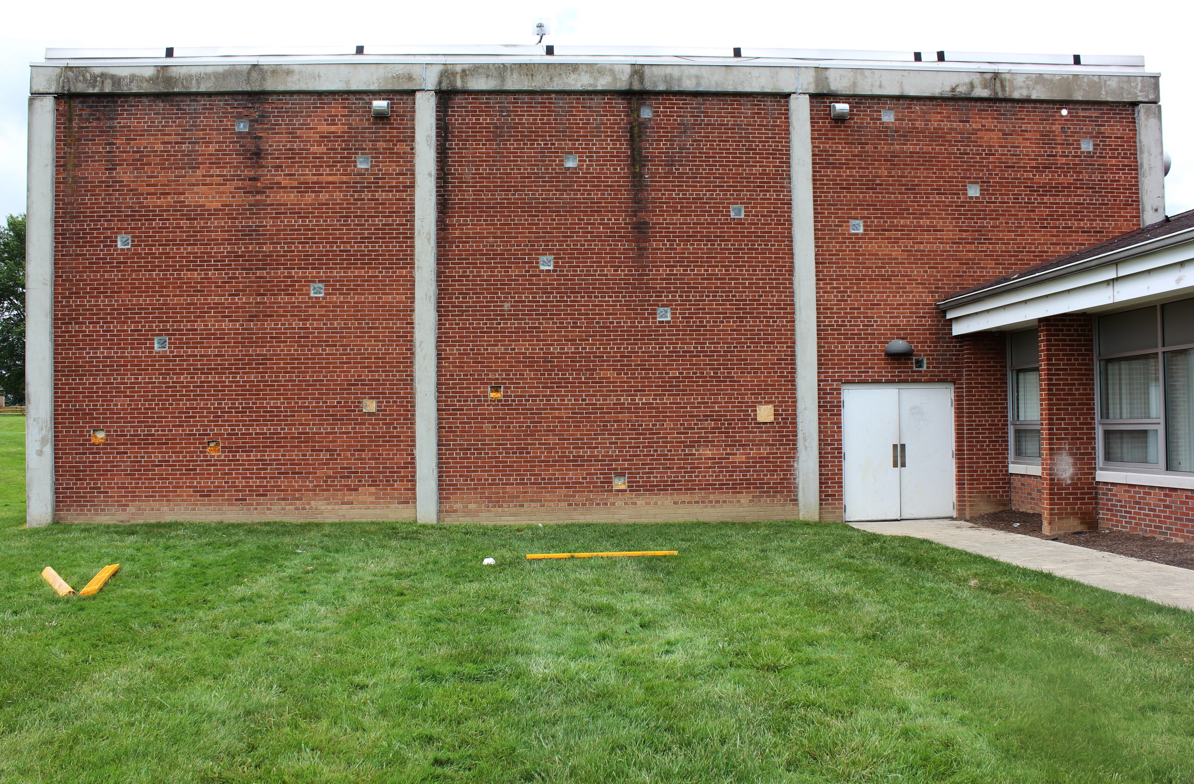 The side of the Boys' Village gym shows its age with weathered bricks and broken windows